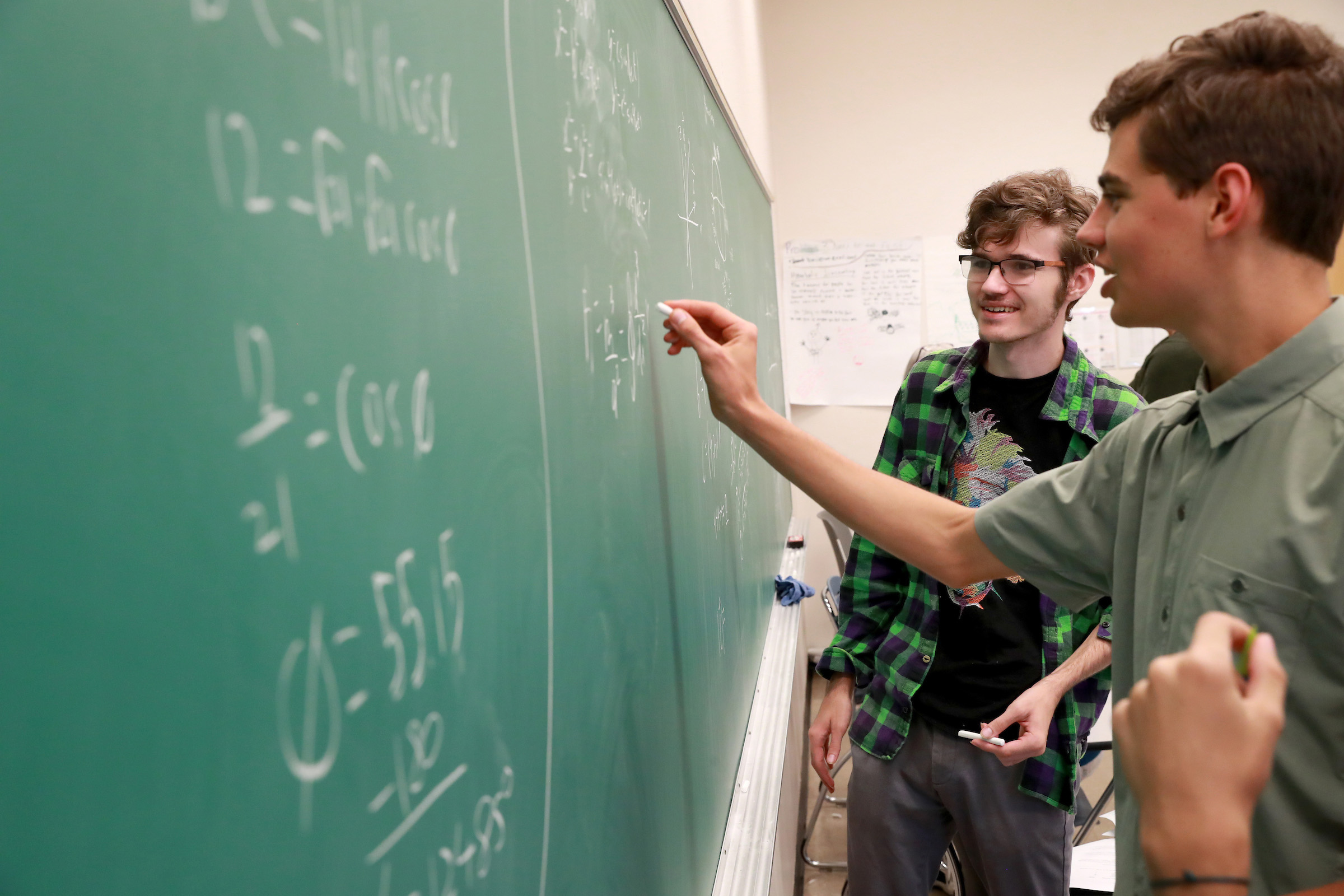 Students at the chalkboard in a classroom.