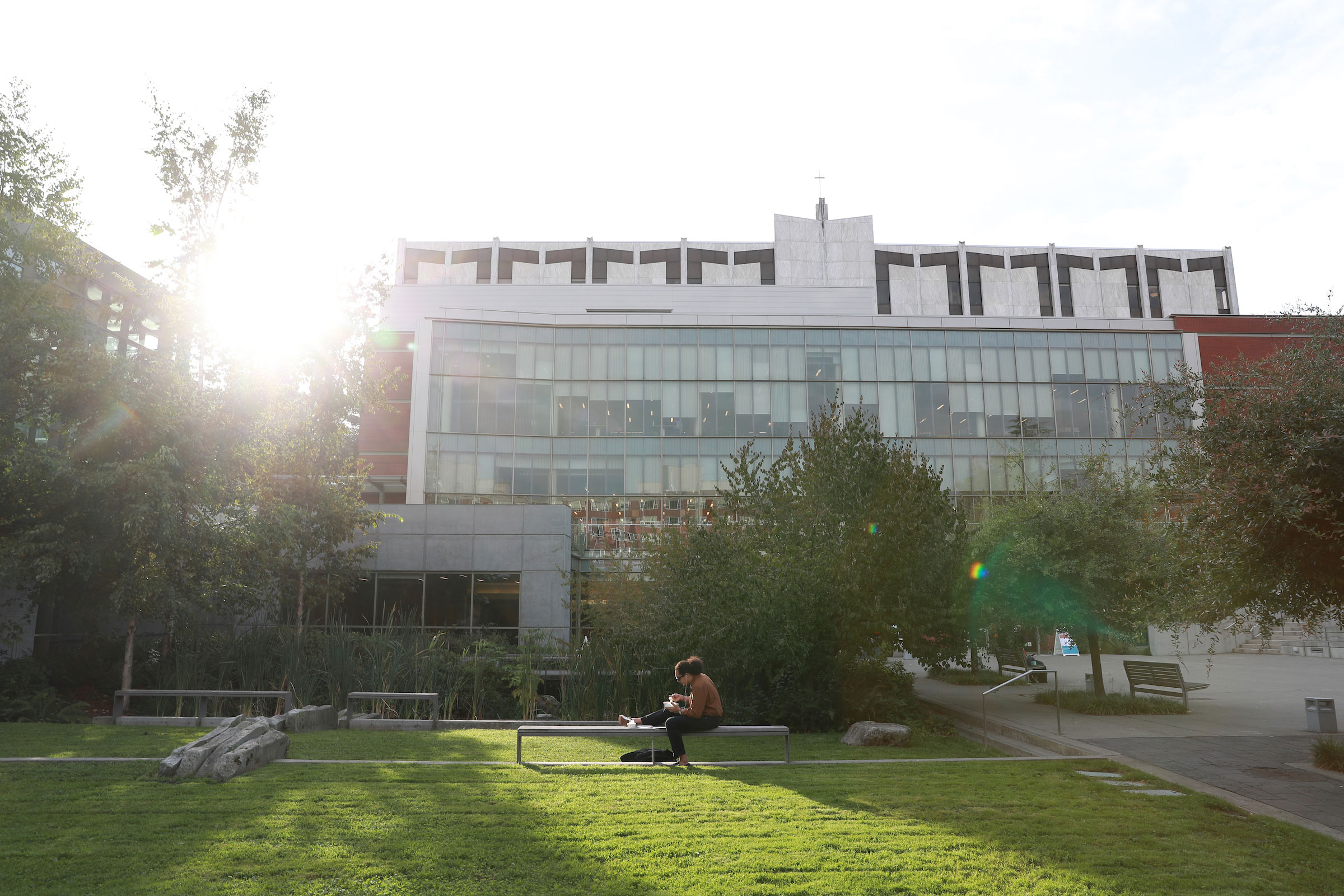 Student at outdoor table near Lemieux Library.