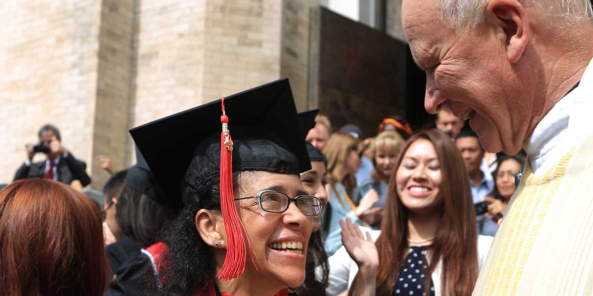 Father Pat Howell greets students in this photo from the Baccalaureate Mass in 2013