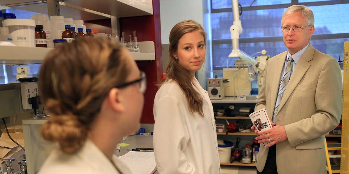 Dean Michael Quinn with students at a Science Research Open House