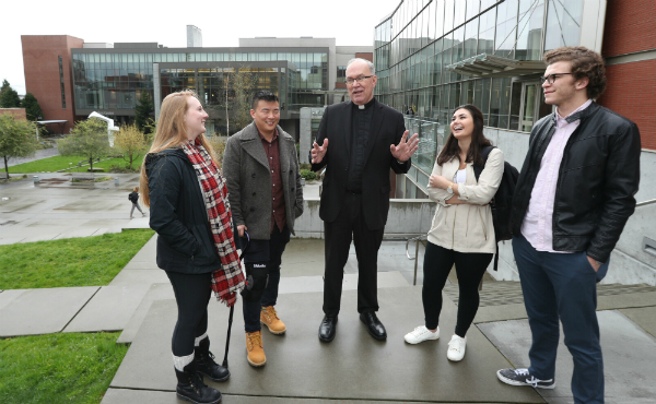 Stephen V. Sundborg, S.J. with four students