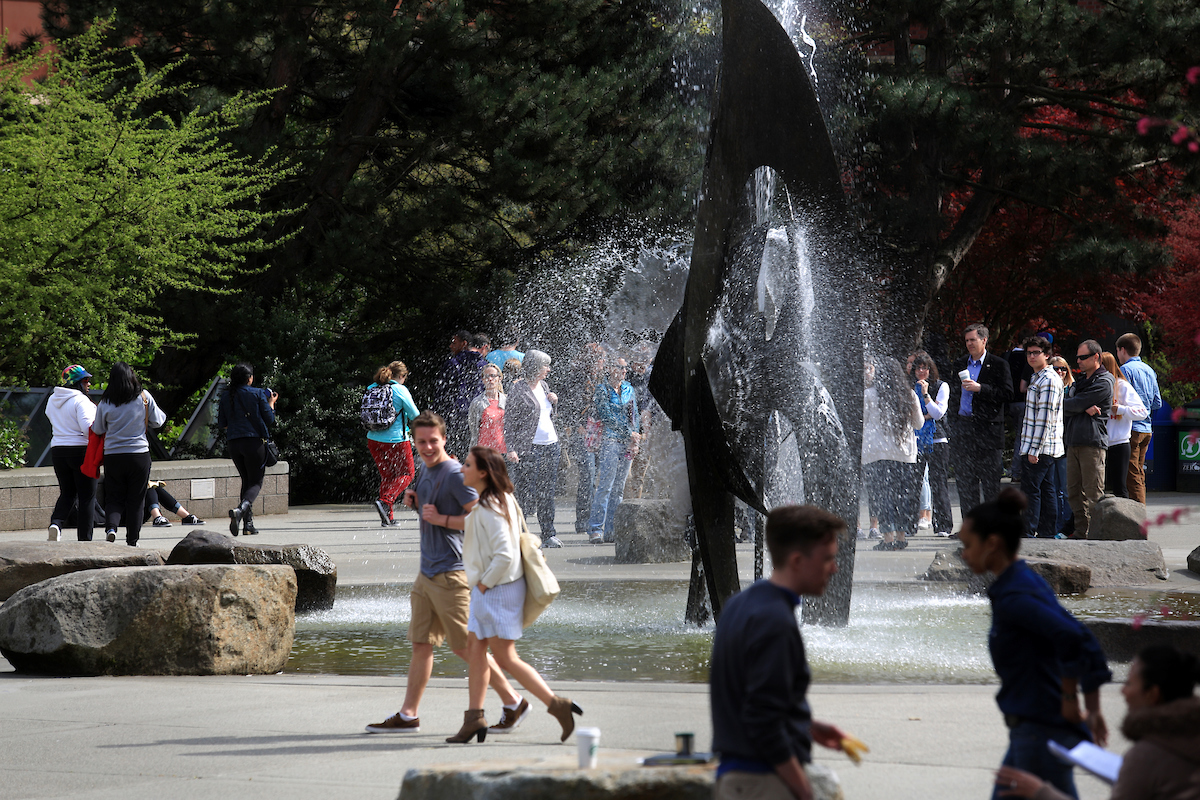 Faculty are using creativity and flexibility in remote instruction. (Photo features students walking on campus near the Quad fountain.)