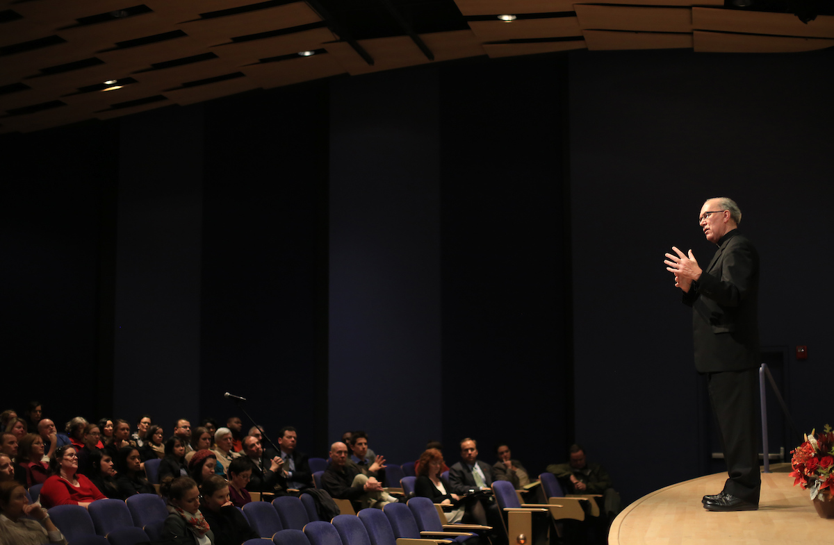 Father Steve speaking at Pigott Auditorium.