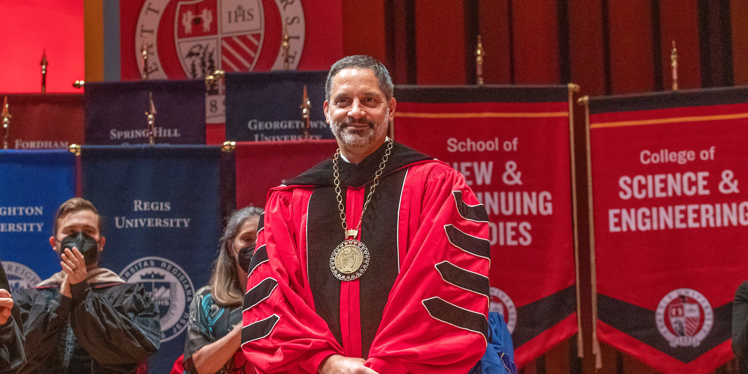 Eduardo Peñalver on stage, wearing academic regalia, at Benaroya Hall.