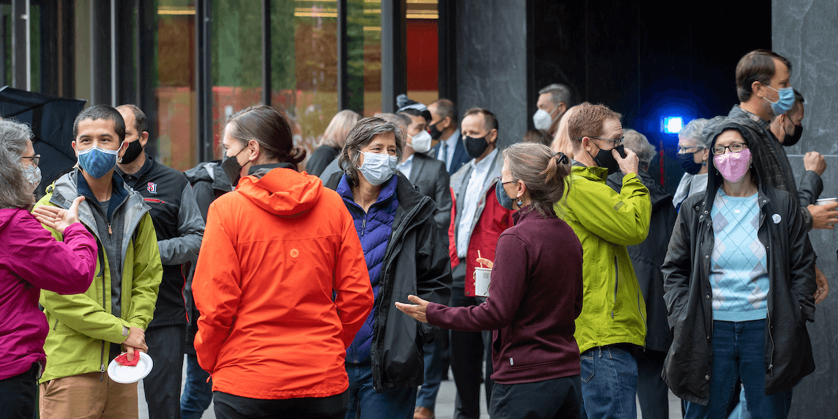 Faculty and staff wearing face coverings outside.