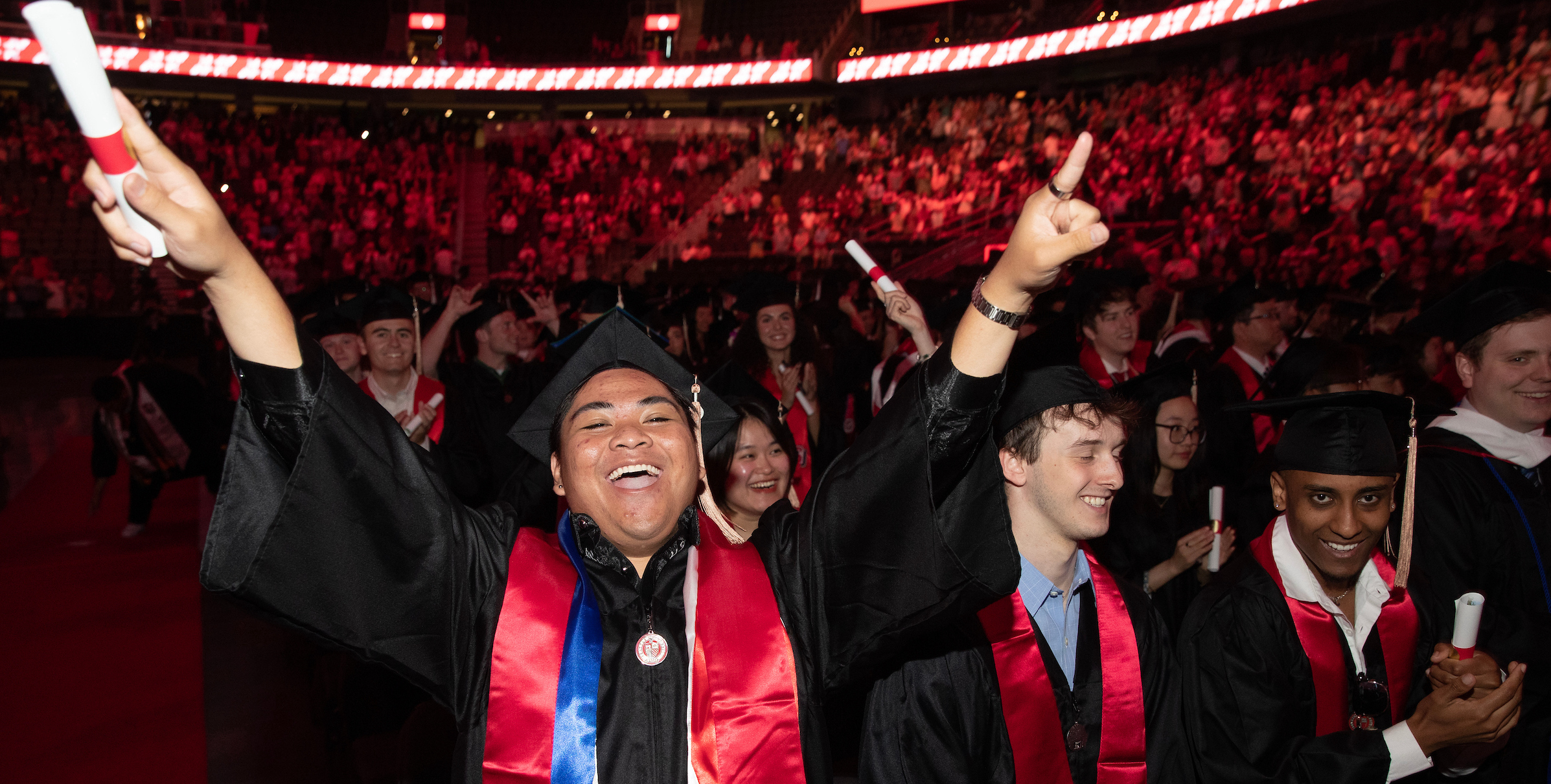 Student with hands in the air at the UG commencement ceremony