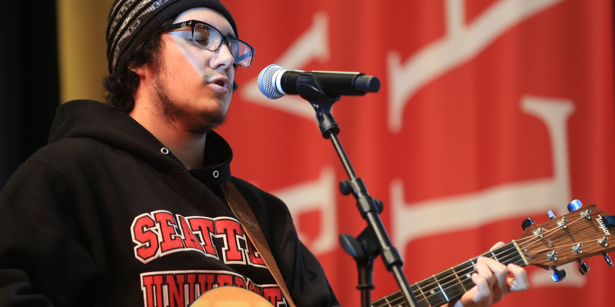 SU student Fred Seymour performing a song on guitar