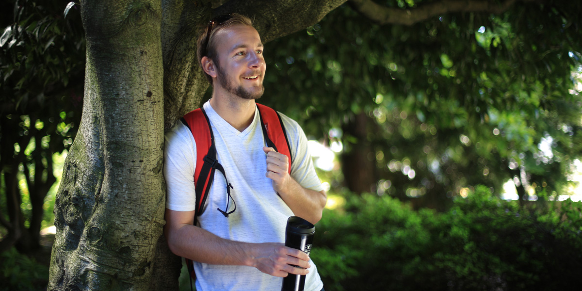 Eric Sype leaning on a large tree