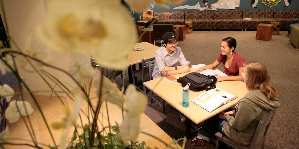   Three students sit around table in Campion Lobby